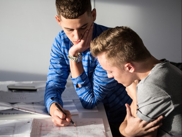 two men looking over technical drawings two men looking over technical drawings